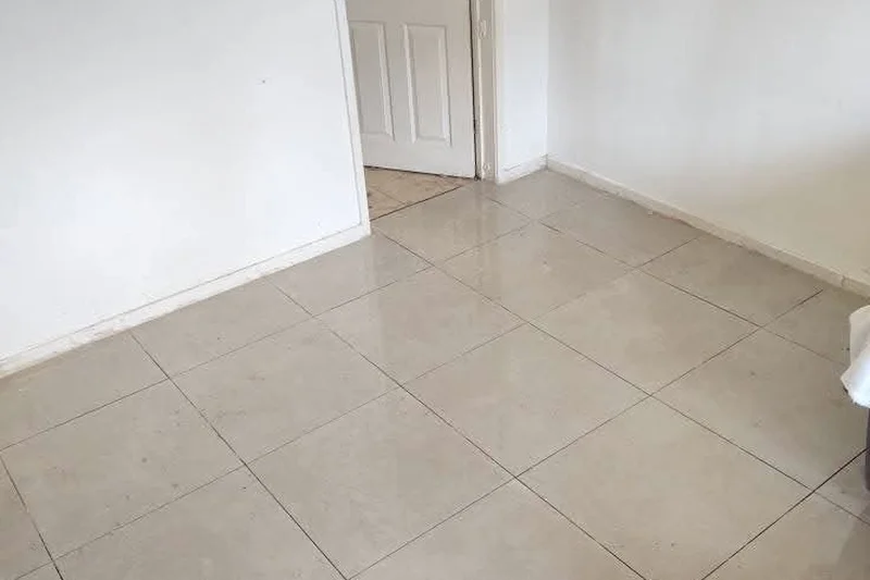 Freshly tiled cream floor in empty room — Mitchell Hunter Handyman, Whitstable | mitchhandyman.co.uk